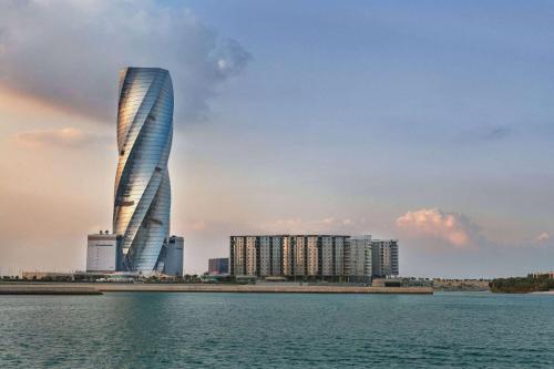 a rendering of a tall building with a city at Wyndham Grand Manama in Manama