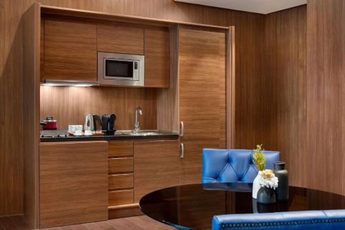 a room with a kitchen with a table and a microwave at Wyndham Grand Manama in Manama