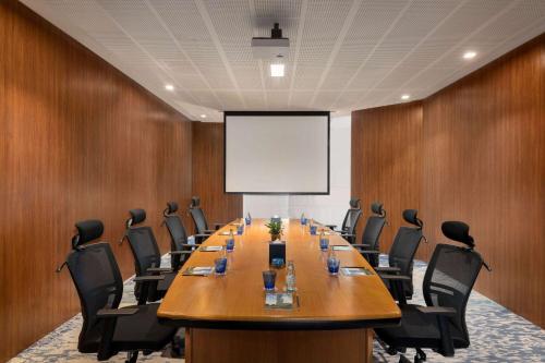 a conference room with a large table and chairs at Wyndham Grand Manama in Manama