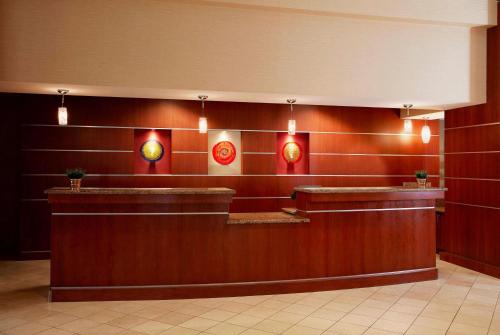 a lobby with red walls and a counter with lights at Wyndham Cleveland Airport in Cleveland