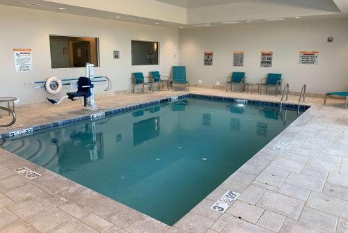 a swimming pool with blue chairs in a room at La Quinta Inn & Suites by Wyndham Holbrook Petrified Forest in Holbrook