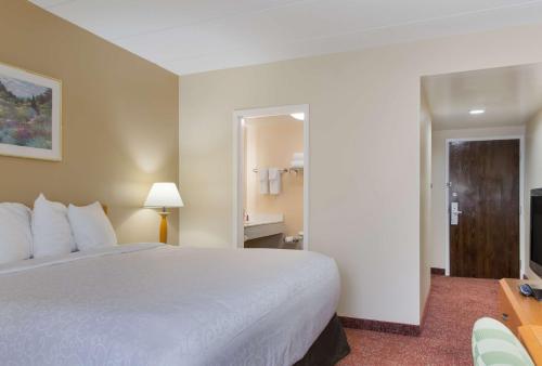 a hotel room with a bed and a television at All Seasons Inn & Suites in Smithfield