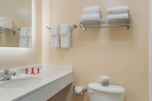 a bathroom with a sink and a toilet and towels at All Seasons Inn & Suites in Smithfield