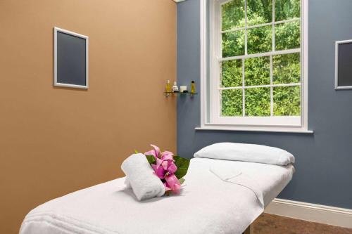 a room with two beds and a window at Trenython Manor Resort in Fowey