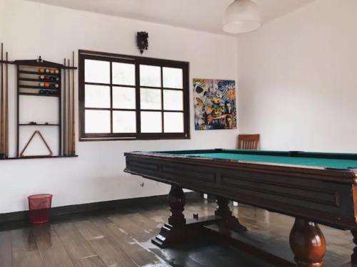 a room with a pool table and a window at Cieneguilla Eco House in Cieneguilla