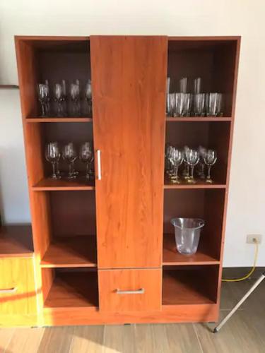 a wooden cabinet with wine glasses in it at Cieneguilla Eco House in Cieneguilla