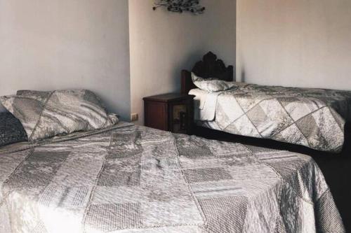 a bedroom with two beds and a night stand at Cieneguilla Eco House in Cieneguilla