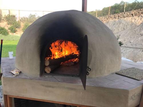 a pizza oven with a fire inside of it at Cieneguilla Eco House in Cieneguilla