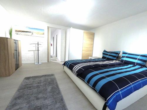 1 dormitorio con 1 cama con sábanas azules y blancas en F-1107 Ferienwohnungen Schilfhalm FeWo 03 1 sep Schlafzimmer, Außennbereich, en Garz
