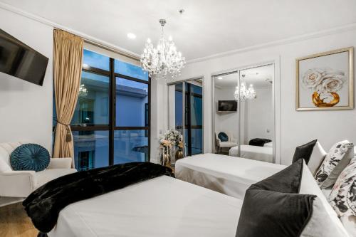 una camera da letto con due letti e un lampadario di The Prestigious Penthouse ad Auckland