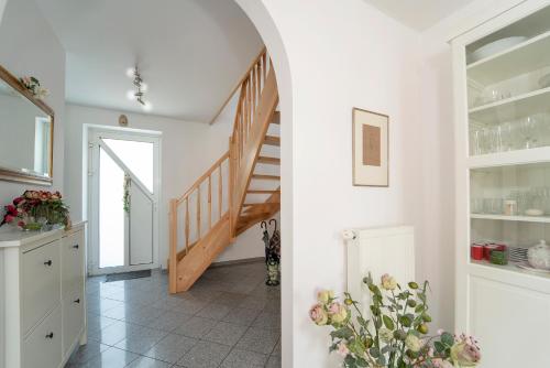 een hal met een trap en een kamer met bloemen bij Casa della Pera in Süssau