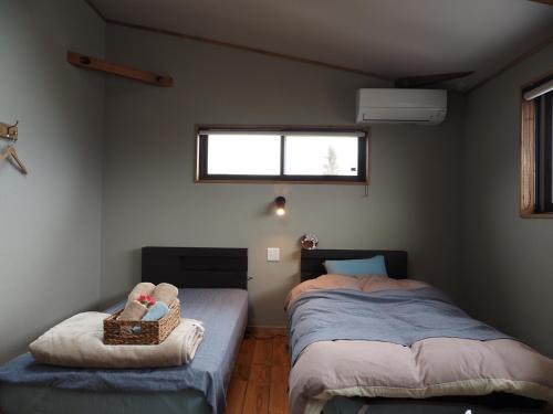 a bedroom with two twin beds and a window at CANOA GUEST HOUSE A room - Vacation STAY 50937v in Ikeda