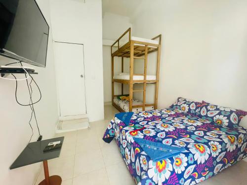 a living room with a bed and a flat screen tv at Hostal Badillo SV in Cartagena de Indias