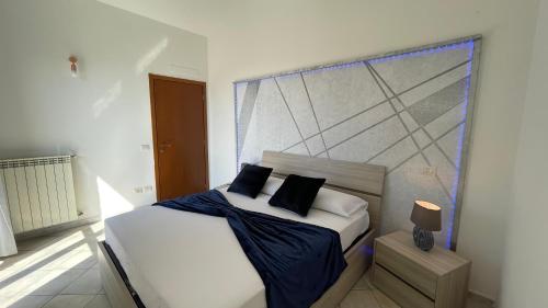 1 dormitorio con cama blanca y almohadas negras en DeHomes - Assago Forum en Buccinasco