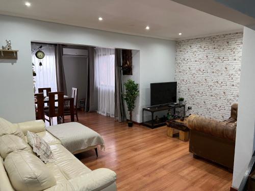 a living room with a couch and a tv at Gran Apart Hotel Chillan - Monte Piedra - Factura Empresas - Parking - wifi - servicio adicional pensión completa in Chillán