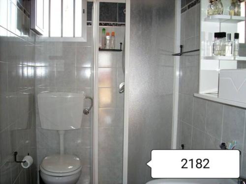 een badkamer met een toilet en een glazen douche bij Veranda Nasca in Donnalucata