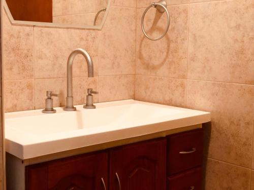 y baño con lavabo blanco y espejo. en Casa El Descanso en San Antonio de Arredondo