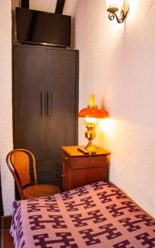 a bedroom with a bed and a cabinet and a lamp at La Ronda in Guatavita