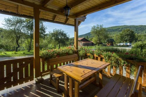 a wooden deck with a wooden table and benches at Ranch Jelov Klanac in Rakovica