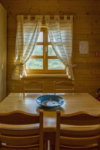 a wooden table with a plate on it in front of a window at Ranch Jelov Klanac in Rakovica