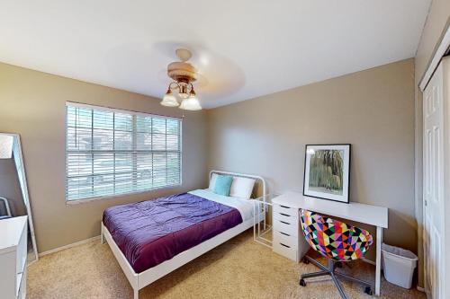 1 dormitorio con cama, escritorio y ventana en Chandler Escape, en Chandler