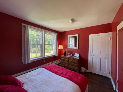 a bedroom with red walls and a bed and a window at Stone Hearth Inn and Eatery in Chester
