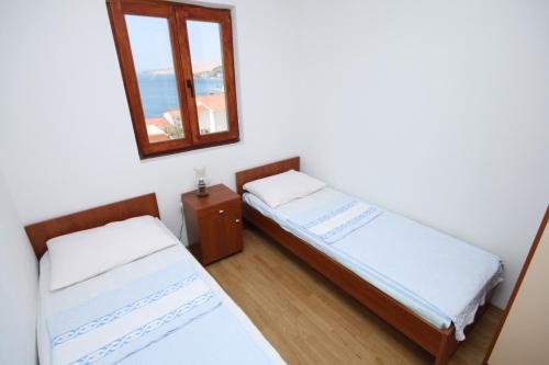 two beds in a room with a mirror at Apartment Metajna 6337b in Zubovići