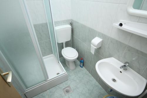 a bathroom with a toilet and a sink and a shower at Apartment Metajna 6337b in Zubovići