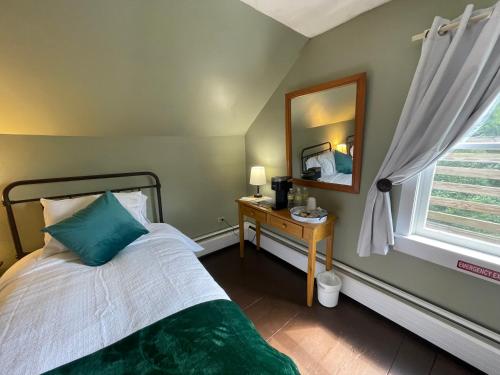 a bedroom with a bed and a mirror and a window at Stone Hearth Inn and Eatery in Chester