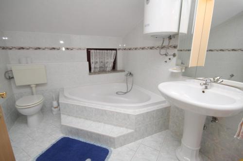 a bathroom with a tub and a sink and a toilet at Apartments with a parking space Novigrad - 7037 in Novigrad Istria