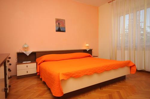 a bedroom with a bed with an orange blanket at Apartments with a parking space Valbandon, Fazana - 7215 in Štinjan