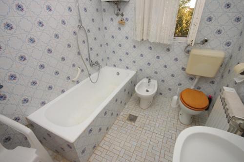 a bathroom with a tub and a toilet and a sink at Apartments with a parking space Valbandon, Fazana - 7215 in Štinjan
