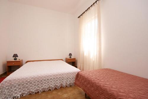 a bedroom with two beds and a window at Apartments by the sea Pag - 6413 in Pag