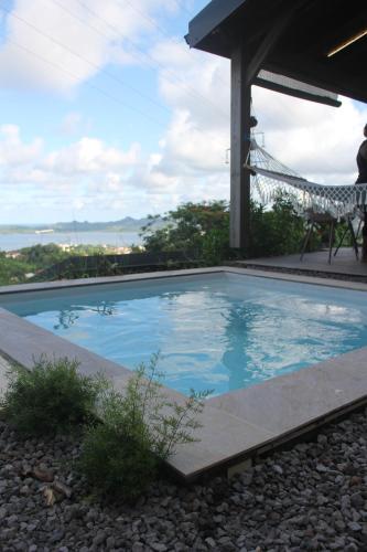a swimming pool with a chair next to it at Lodges Mont-Vert in Le Robert
