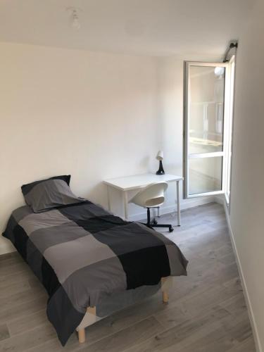 ein Schlafzimmer mit Bett, Schreibtisch und Fenster in der Unterkunft Evry Time in Courcouronnes