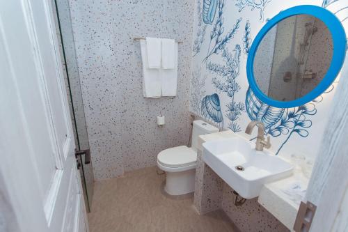 a bathroom with a toilet and a sink and a mirror at SUNTORINI BOUTIQUE HOTEL in Vung Tau