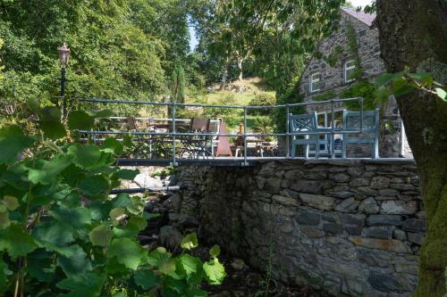 a bridge over a stone wall in front of a house at Cae Lleci in Dolgellau