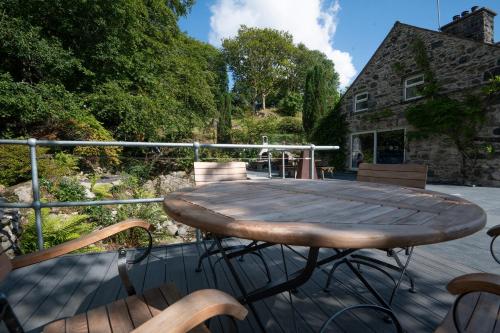 a wooden table and chairs on a deck at Cae Lleci in Dolgellau