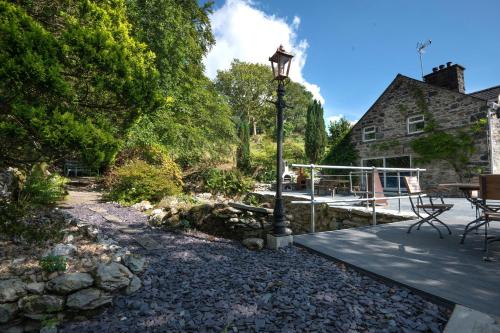 a stone walkway leading to a house with a lamp at Cae Lleci in Dolgellau