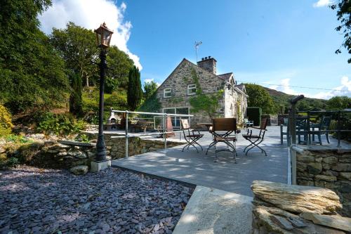 a patio with chairs and a table in front of a house at Cae Lleci in Dolgellau
