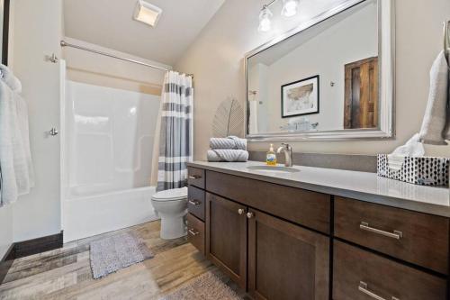 een badkamer met een wastafel, een toilet en een spiegel bij Altitude Adjustment- Panoramic Views, Sleeps 12 in Lead