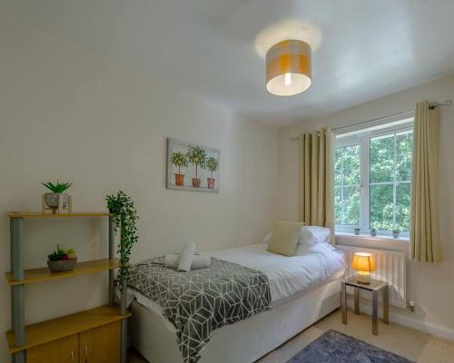 a bedroom with a bed and a window at Chapel Break, 2 Bed, 2 Bathroom House With Parking & Fast Wifi in Norwich