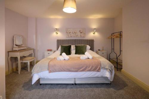 a bedroom with a large bed with green pillows at Yoxford House, Ginger & Gold Ltd in Norwich