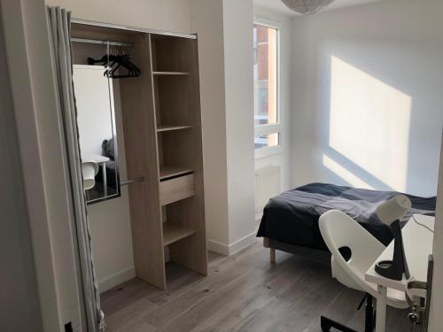 1 dormitorio con cama, escritorio y ventana en Évry time, en Courcouronnes