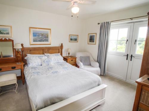 a bedroom with a bed and a chair and a television at Alpen Rose Cottage in Portland