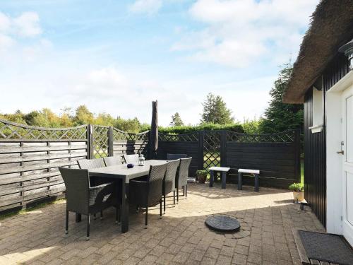 a patio with a table and chairs and a fence at 8 person holiday home in Farsø in Farsø