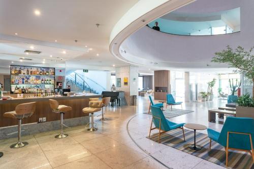a lobby with chairs and a bar in a building at Apartamento em Hotel Beira Mar de Boa Viagem in Recife