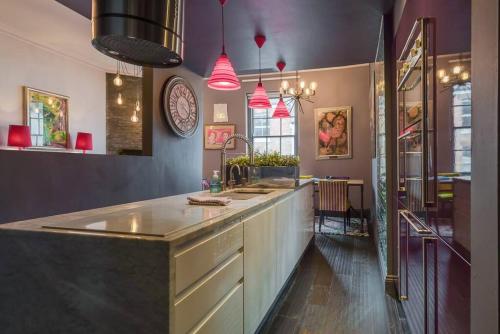 a large kitchen with a counter and a clock on the wall at Elegant Norwich Apartment in The Lanes w Parking in Norwich