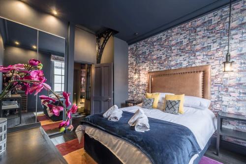 ノリッジにあるElegant Norwich Apartment In The Lanes W Parkingのレンガの壁、大きなベッド付きのベッドルーム1室