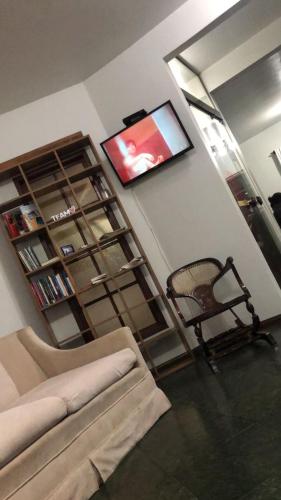 a living room with a couch and a flat screen tv at Pousada da Jaqueira - EPP in Rio das Ostras